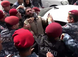 Более десятка красноберетчиков сажают в автомобиль демонстранта